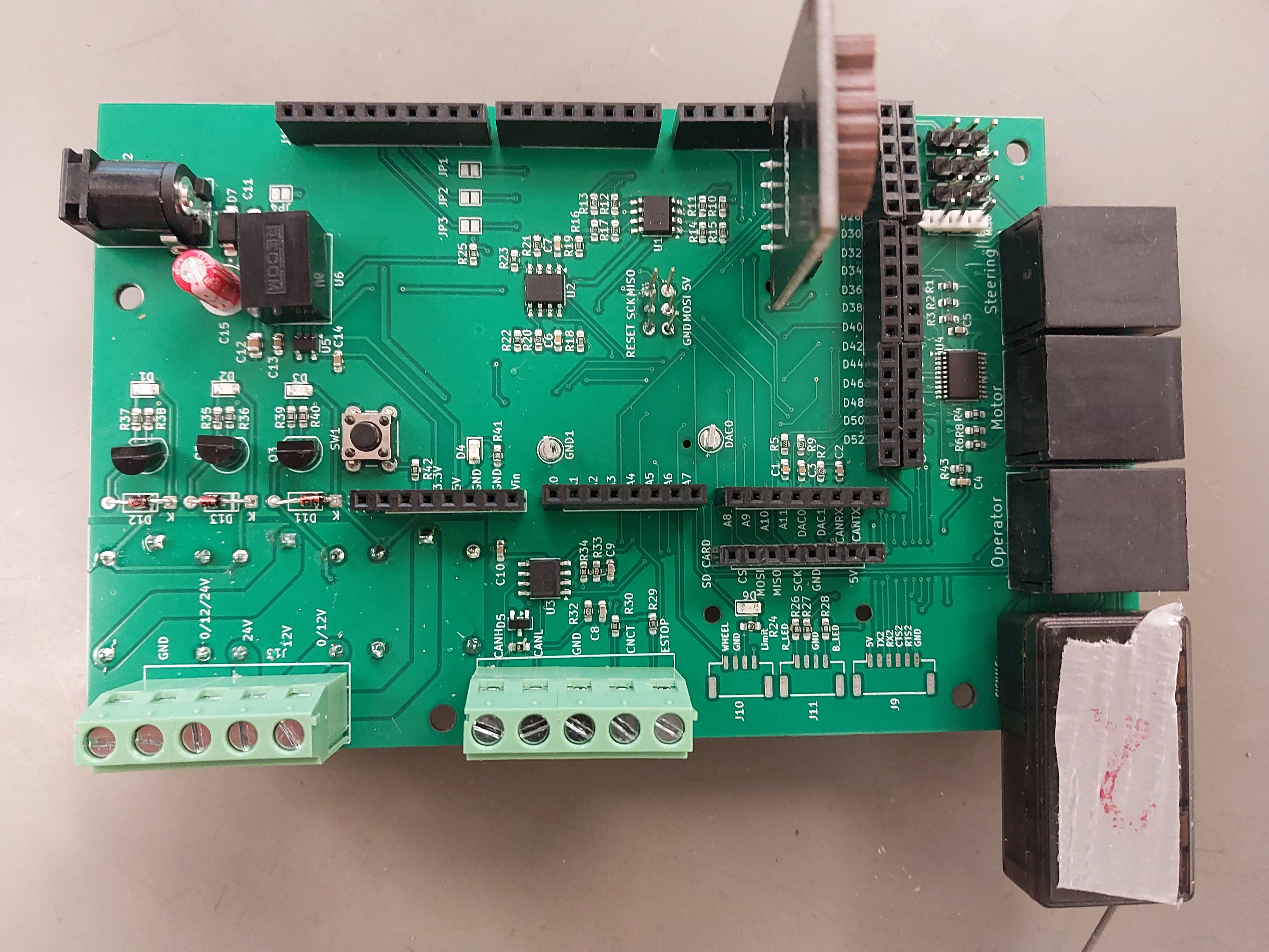 A green PCB on a gray table.