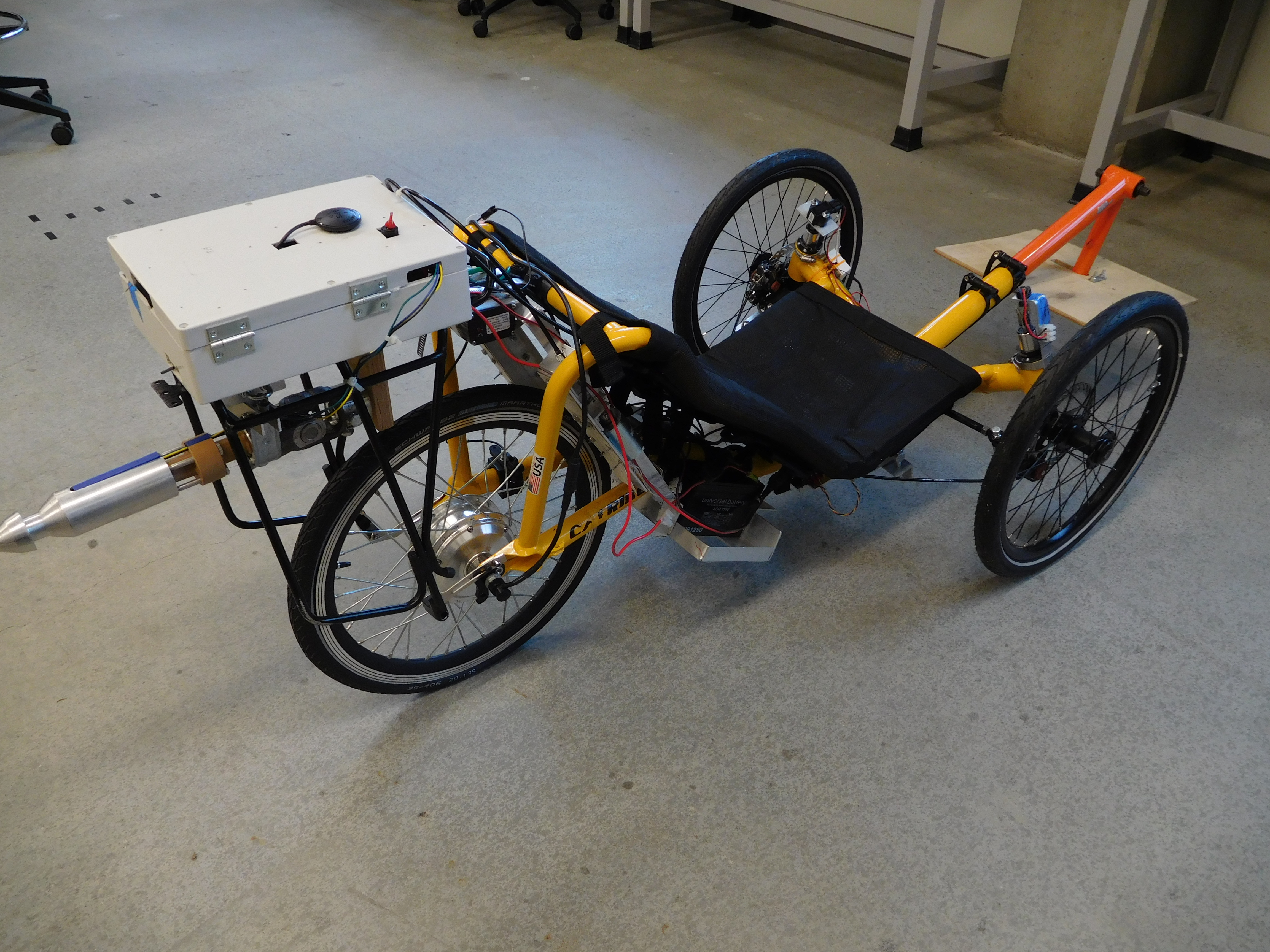 A yellow autonomous trike in a classroom lab.